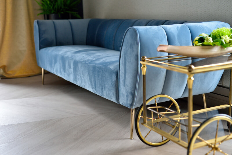 Niebieska dwuosobowa aksamitna sofa w salonie